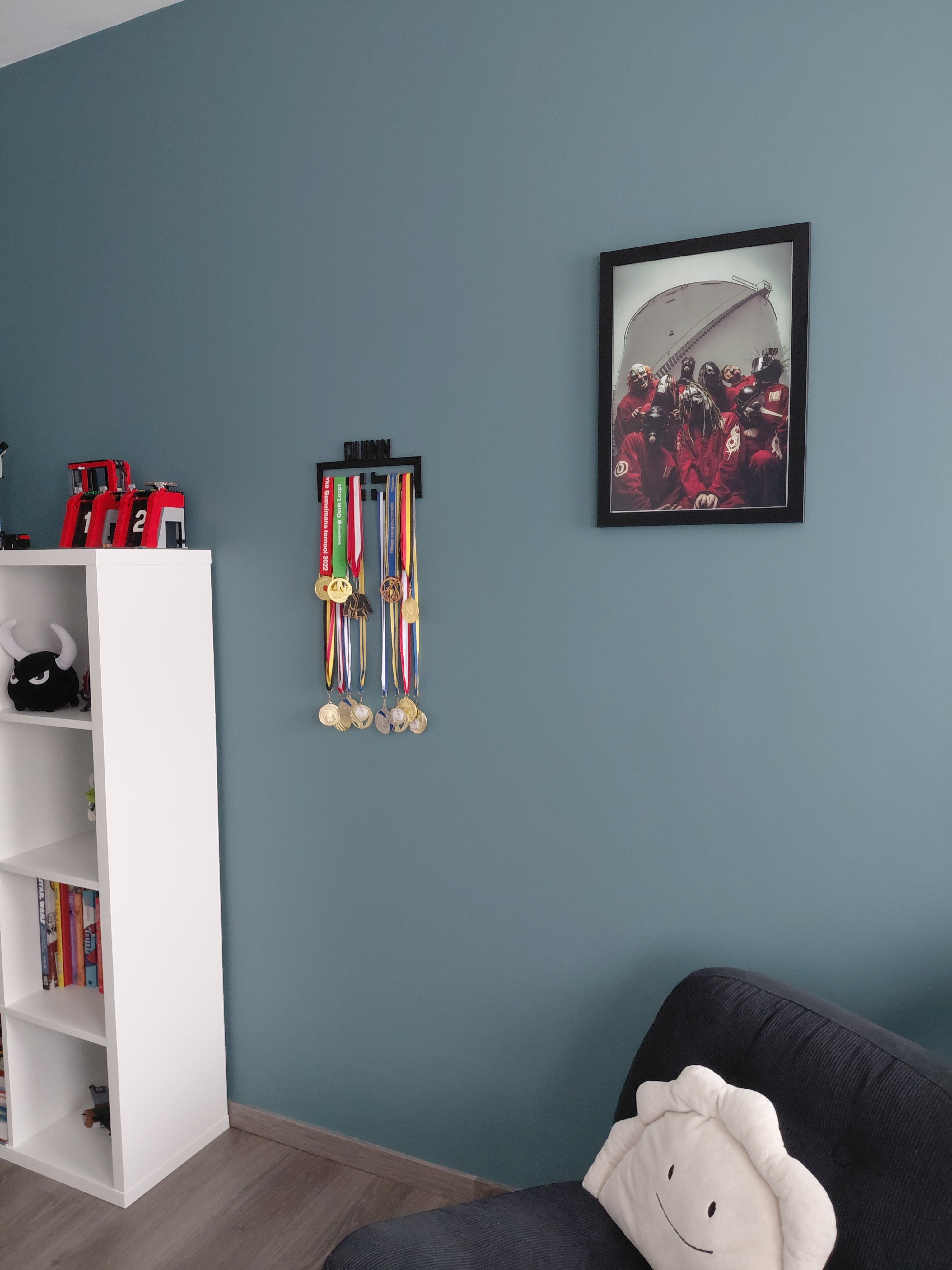 Medaillerek met hardloopmedailles in een ingerichte kamer